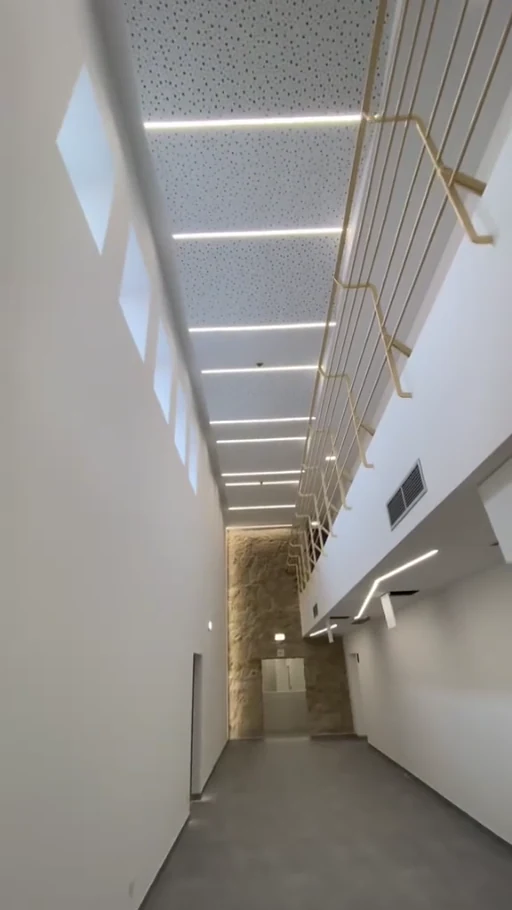 Corredor concluído com teto e iluminação linear, trabalho da T-GESSO